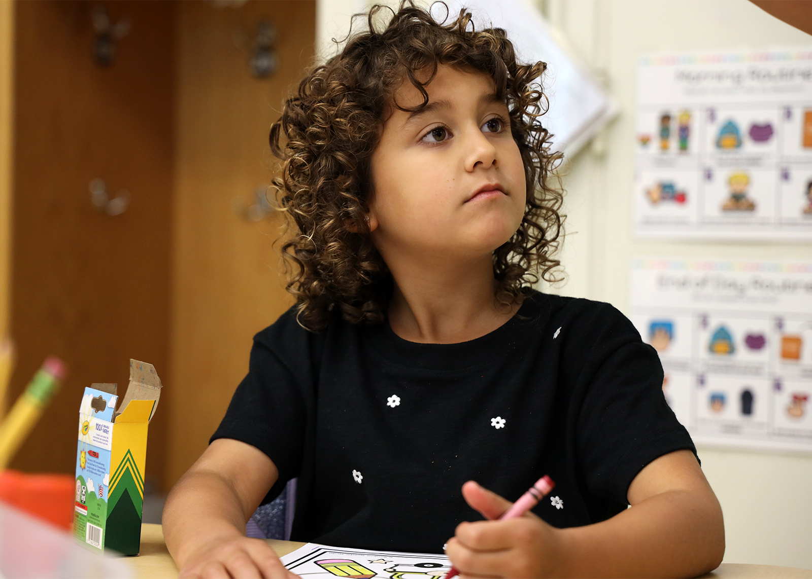 student looking into distance at desk