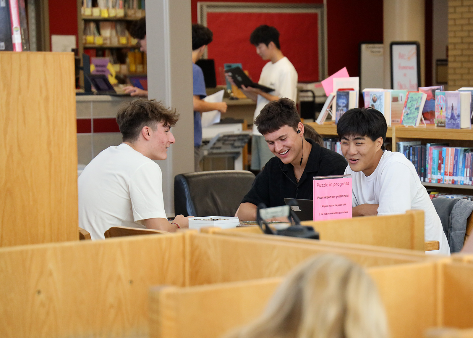 high school students laugh in the library