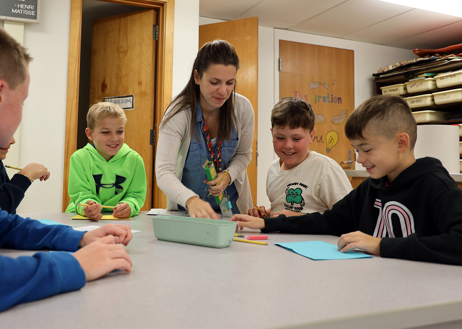 group of students smile with art teacher