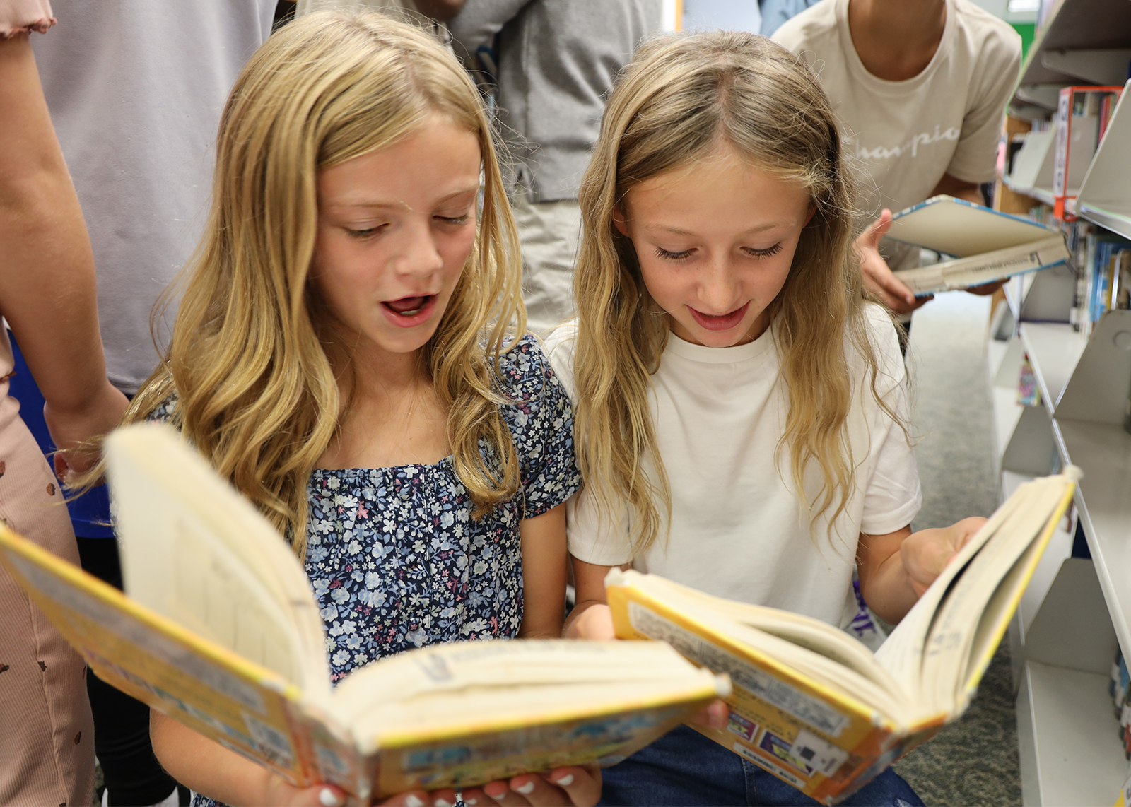 two students reading books and laughing