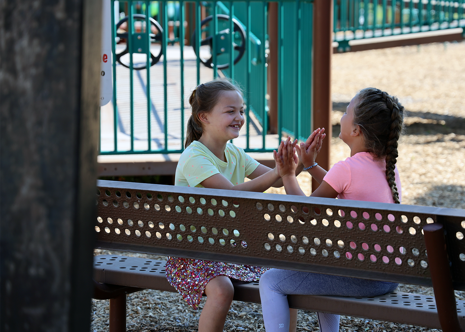 two young students playing handclap game at recess