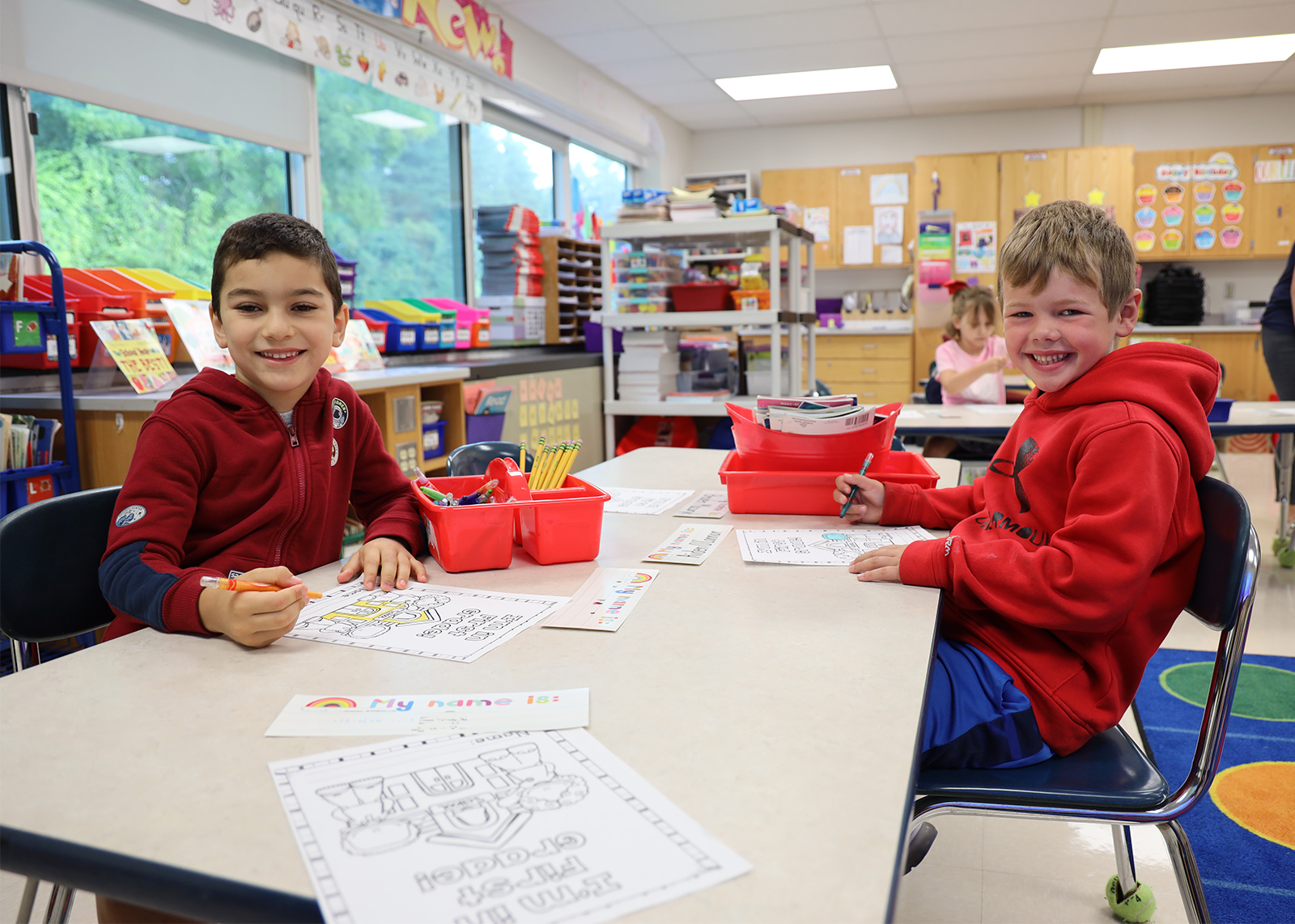 two young students smiling while doing an activity