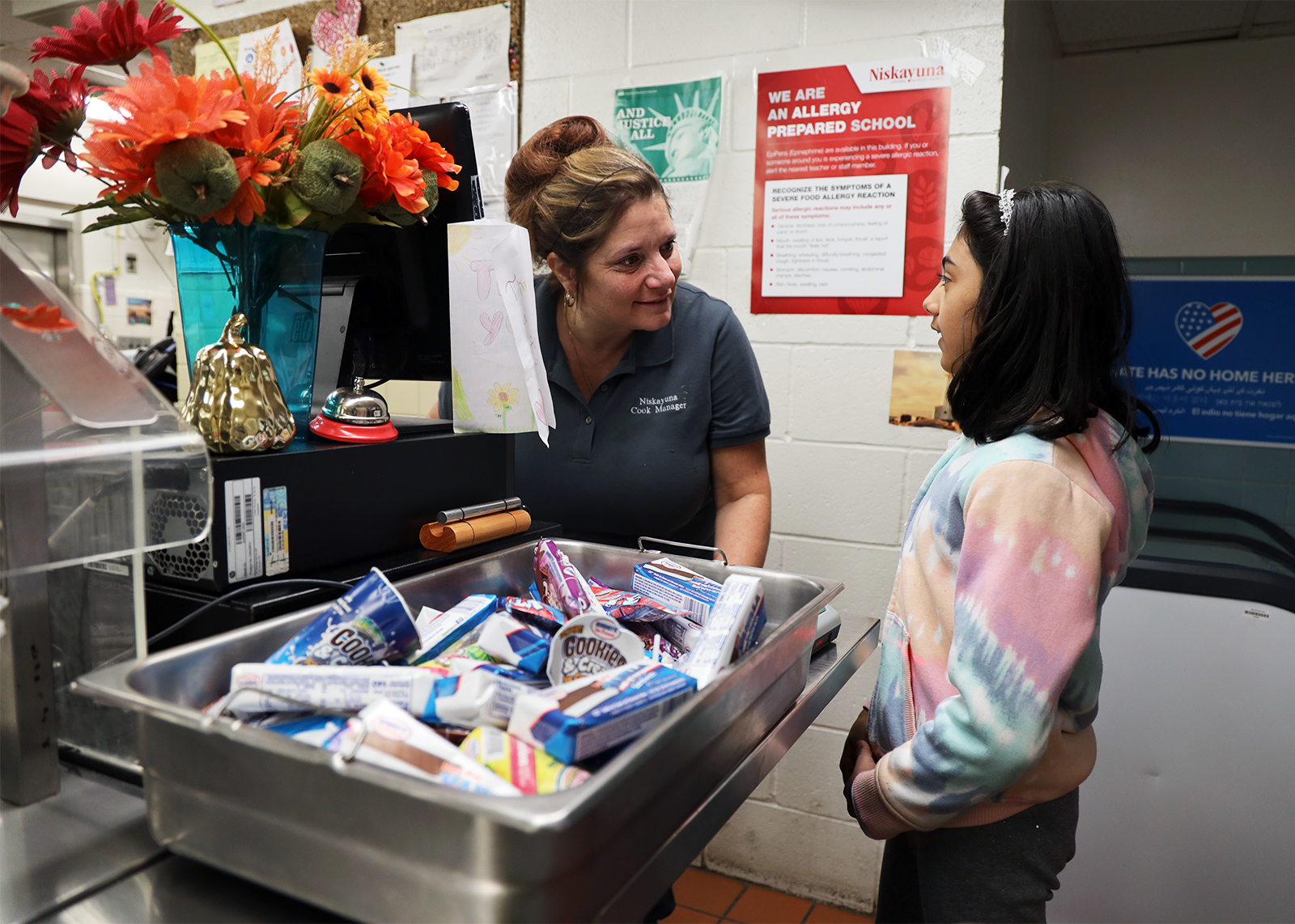 cafeteria worker listens to student in lunch line