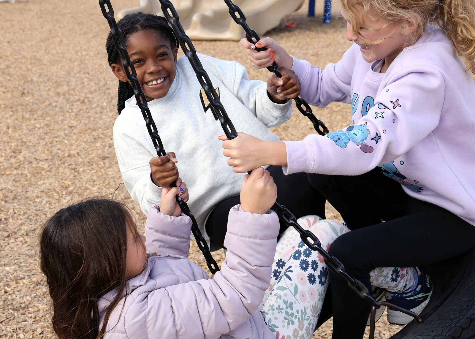 student smiling on tire swing