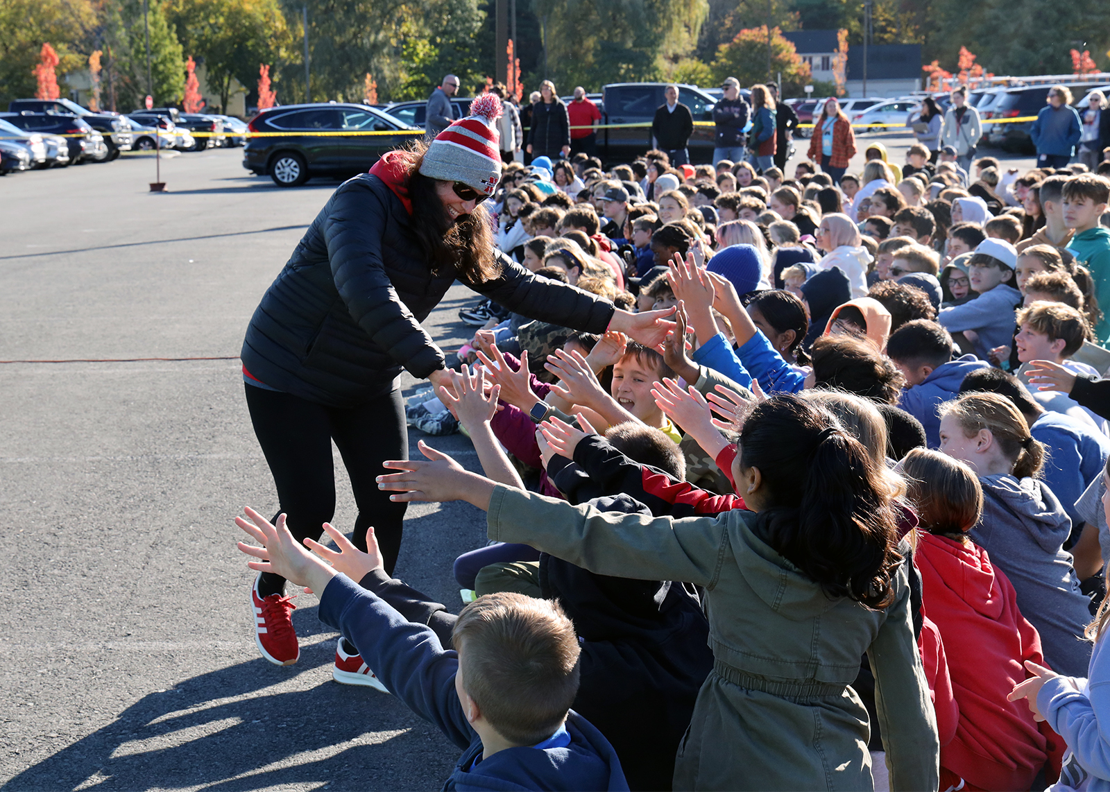 group of students high fiving a teacher