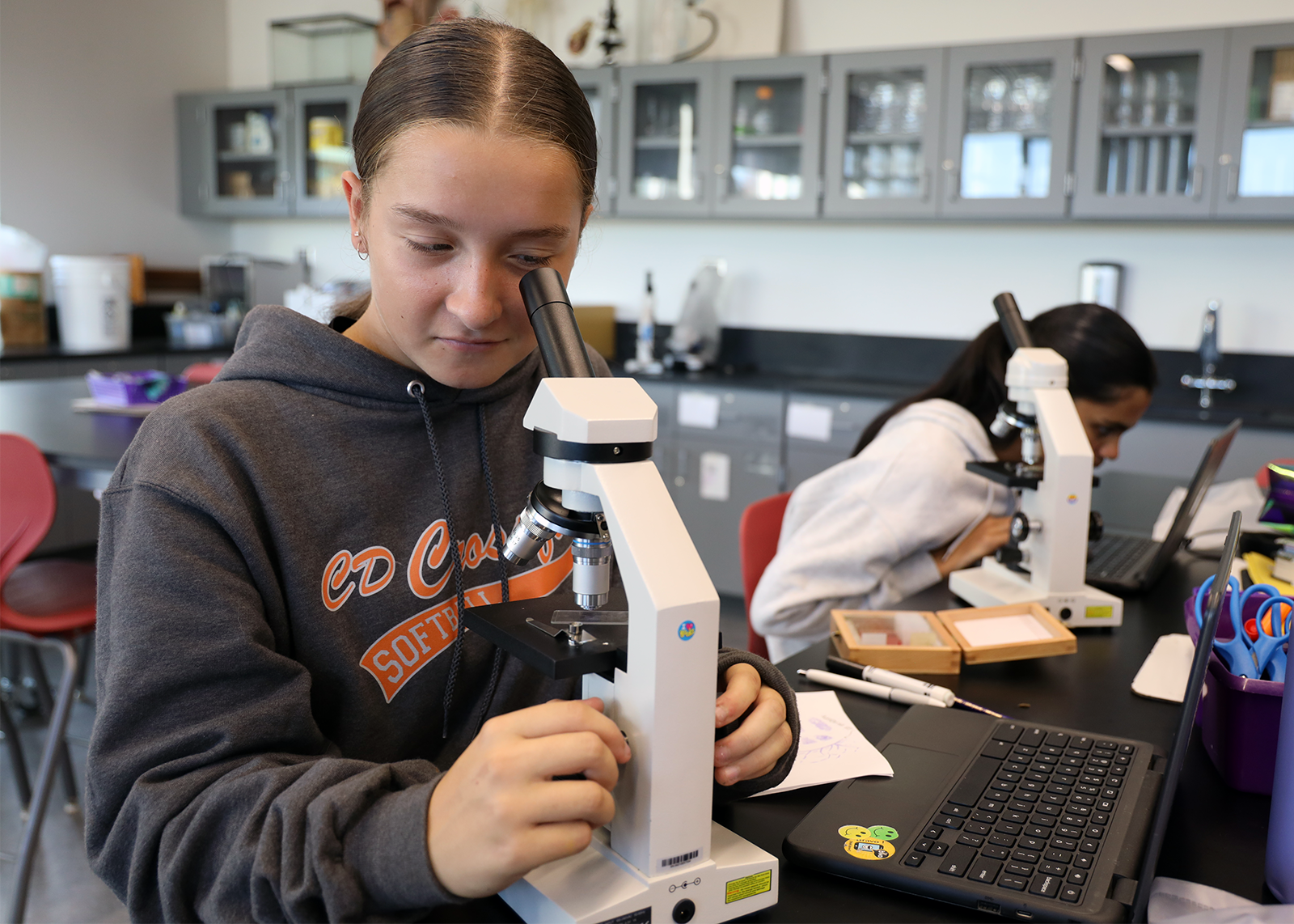 student looking into microscope