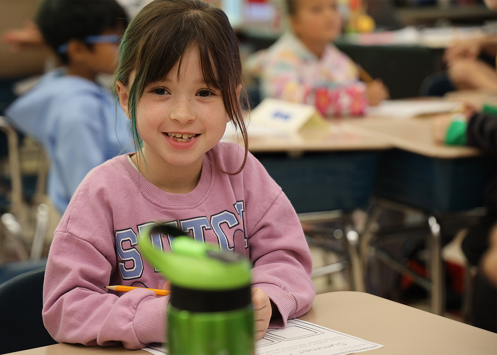 student smiling while at desk