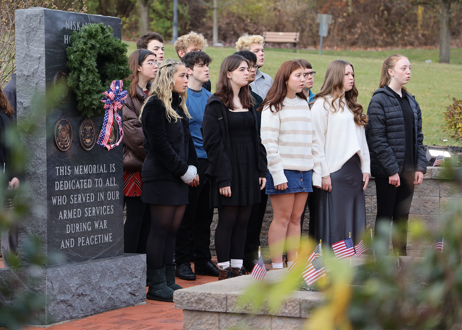 group of high school singers preforming outside at town hall