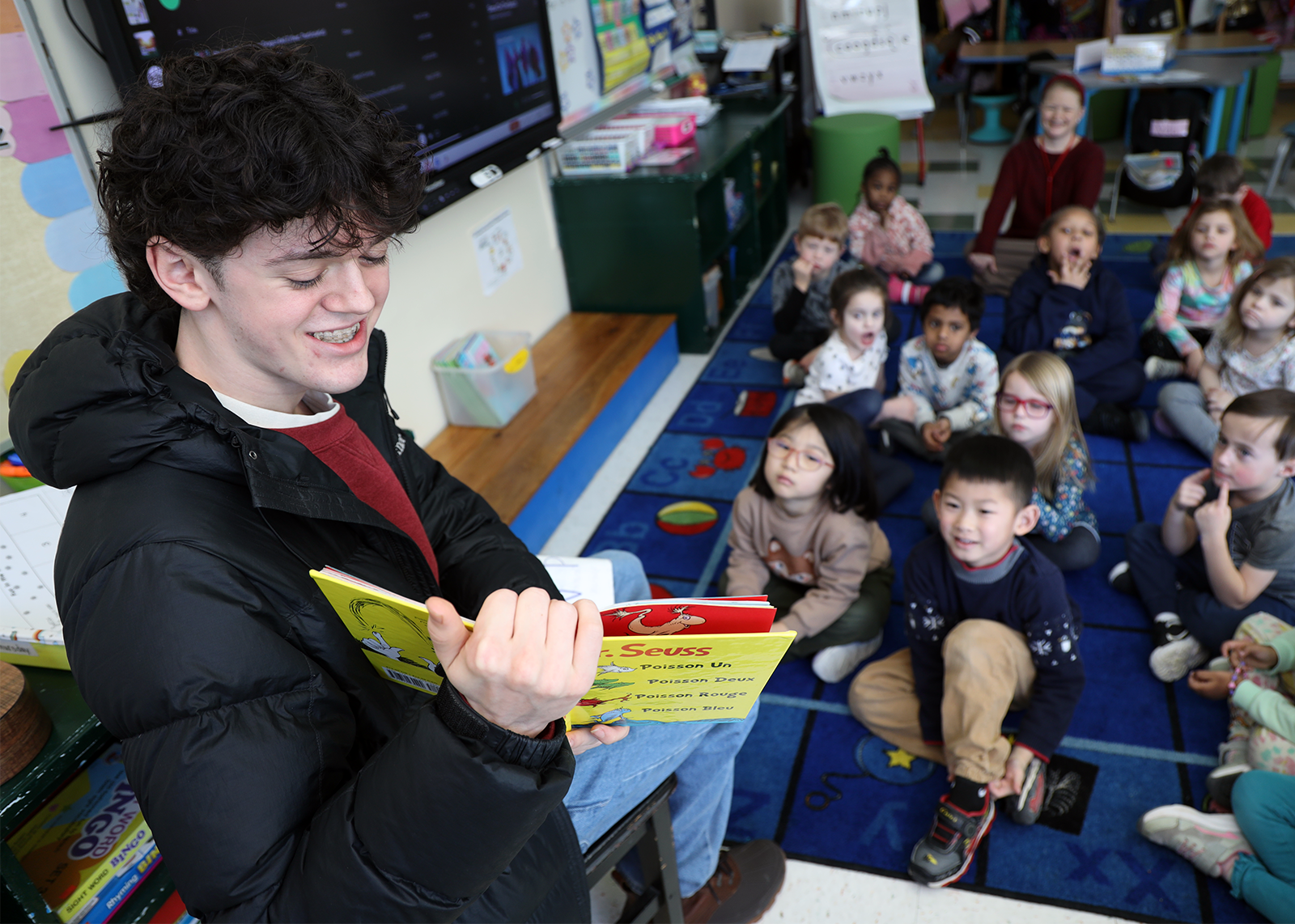 high school student reads to kindergarten class