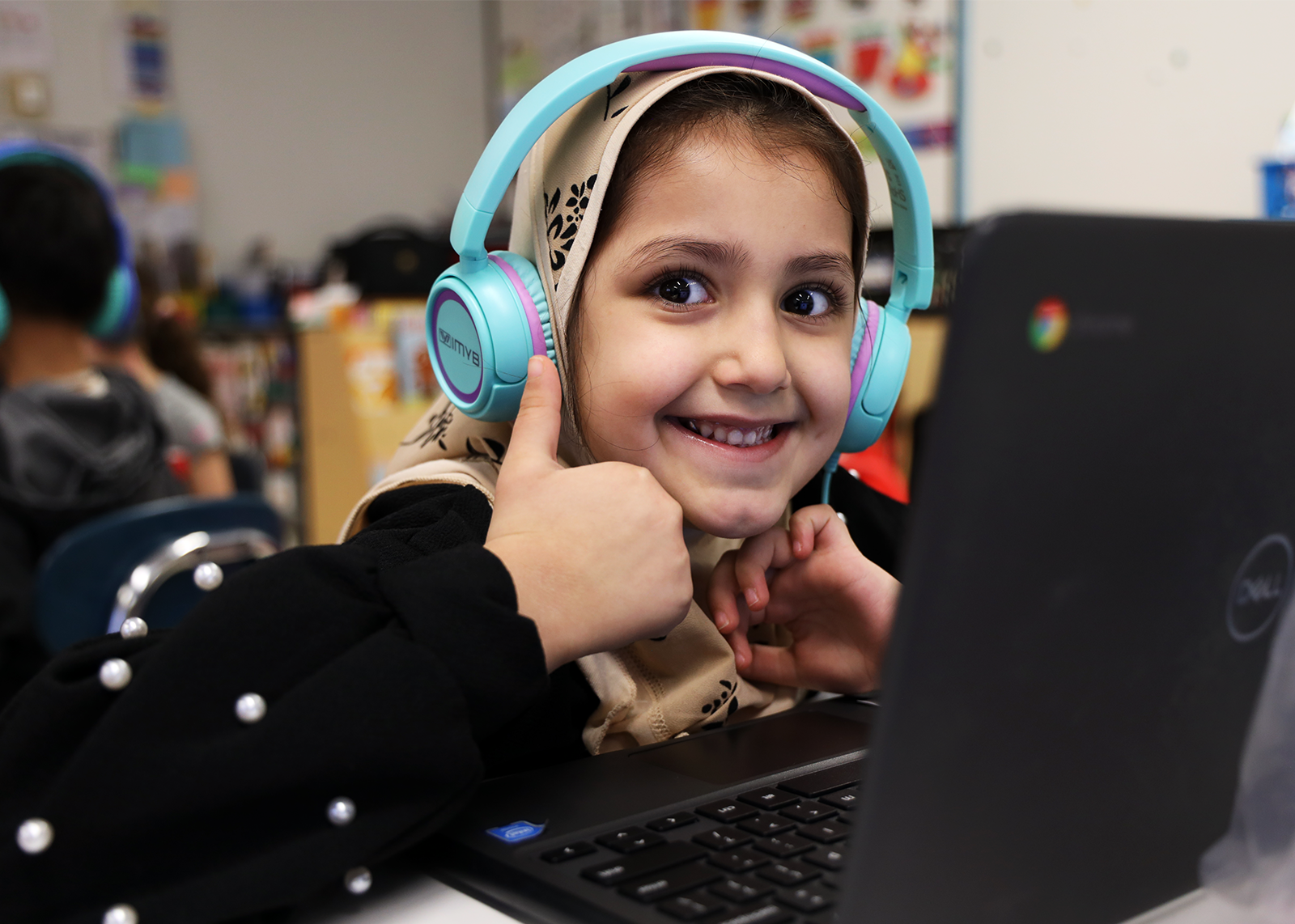 student on computer giving a thumbs up