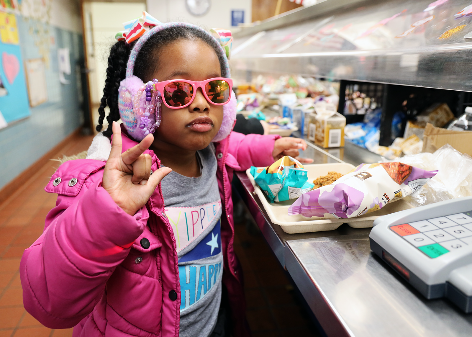 student in lunchline with sunglasses and ear muffs