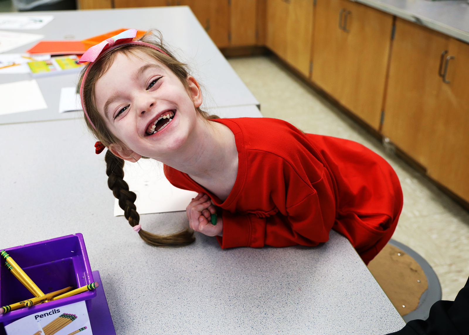 elementary student smiling with missing teeth in art class