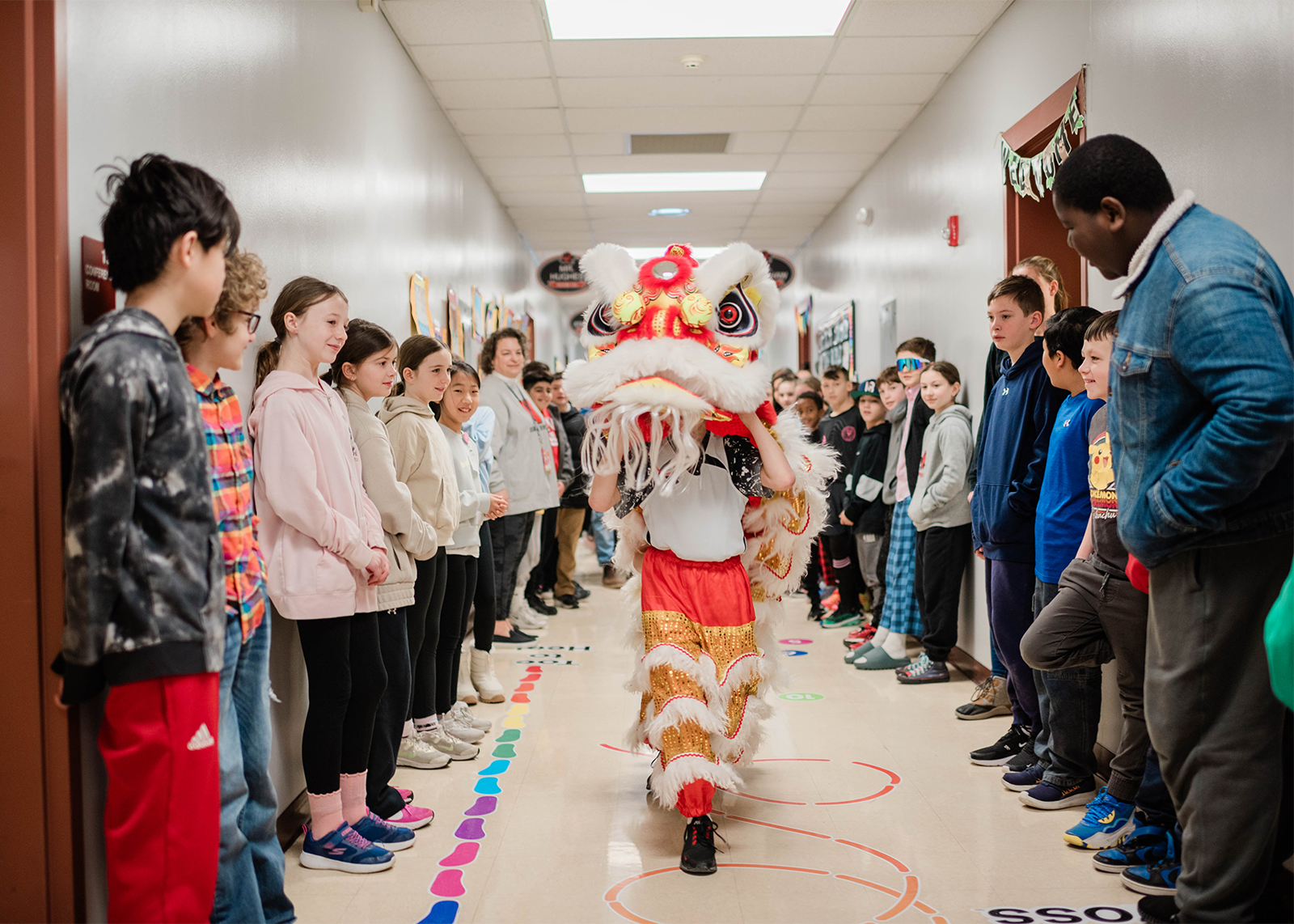 student preform the lion dance in the hallways of elementary school