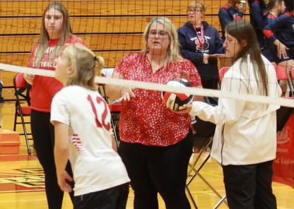 Volleyball Coach Christina Coons with her players midcourt during volleyball practice.